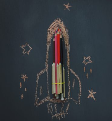 Top view Back to school or business start up background.The rocket create by pencil and drawing by chalk board with around star  on blackboard.copy space.above view.flat lay.